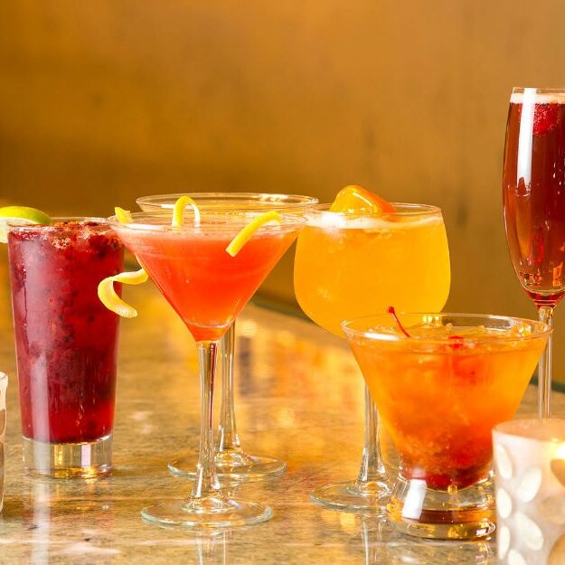 A vibrant assortment of colorful cocktails in various glassware.